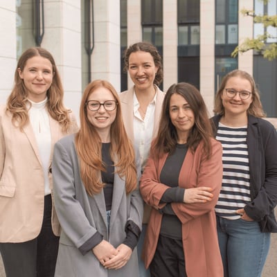 Fünf Mitarbeiterinnen des Kundenmanagements der Little Bird Group stehen gemeinsam vor einem Bürogebäude.